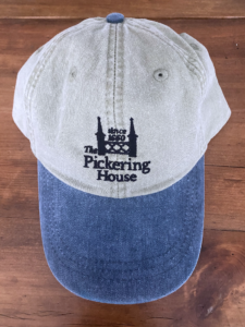 Tan and navy canvas baseball cap with Pickering House logo